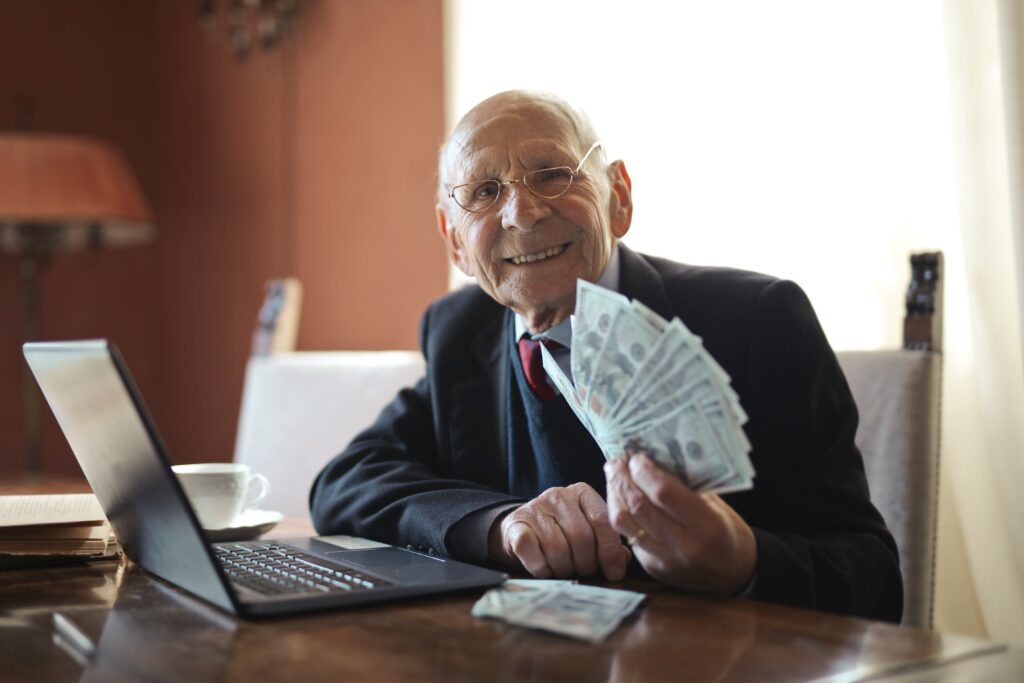 old man holding cash
