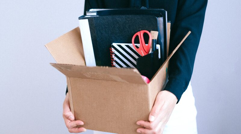woman holding box with her desk stuff