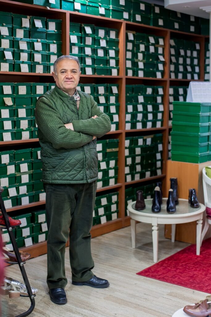 senior man working in shoe store
