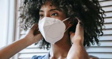 woman putting on N95 mask