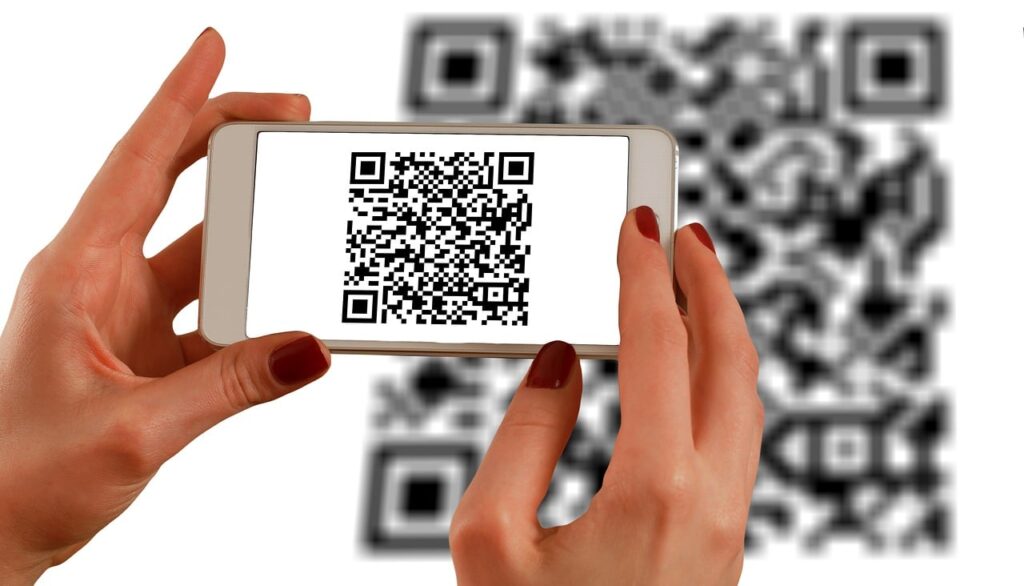 hands holding cell phone scanning QR code